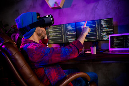 Photo of dreamy excited programmer wear spectacles pointing finger modern device indoors workplace...