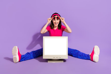 Photo of overjoyed positive lady sitting floor show old device recommend cool offer novelty empty...