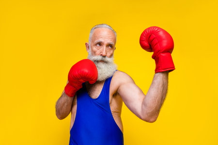 Photo of focused concentrated person wear boxing gloves punch isolated on yellow color background