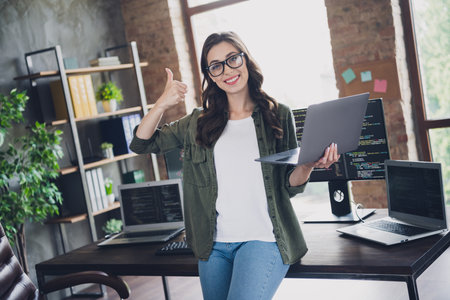 Photo of web designer software expert smart lady hold netbook thumb up satisfied good job media...
