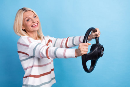 Photo of shiny pretty lady wear striped pullover smiling enjoying driving car empty space isolated blue color backgroundの写真素材