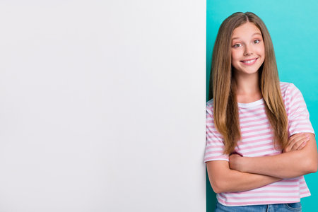 Portrait of cheerful nice person folded arms toothy smile empty space card isolated on teal color backgroundの写真素材