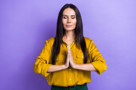Photo of lovely cute lady wear stylish clothes eyes closed arm together pleading help stop war isolated on purple color backgroundの写真素材