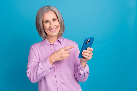 Photo of gorgeous retired lady hand demonstrate modern device buy telephone sale offer isolated on...