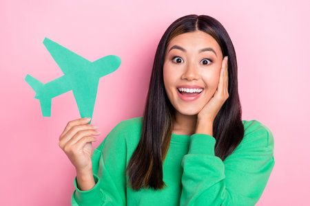 Photo of positive excited lady wear green sweatshirt arms cheek ready new trip isolated pink color backgroundの写真素材