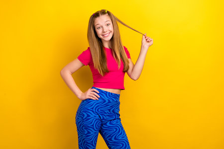 Portrait of optimistic lovely satisfied girl with long hairdo dressed pink top arm on waist hold...