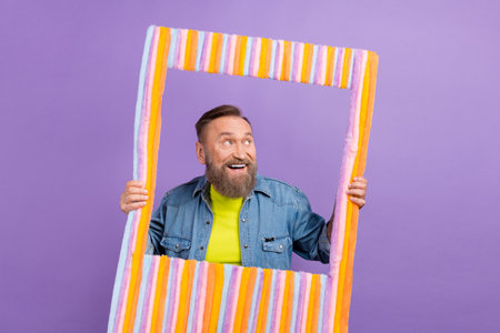 Photo of cheerful granddad arms hold velvet fluffy album moment card look empty space isolated on violet color backgroundの写真素材