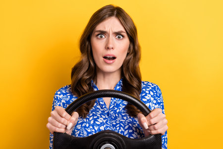 Photo of impressed shocked lady wear print shirt getting in crash driving automobile isolated yellow color backgroundの写真素材