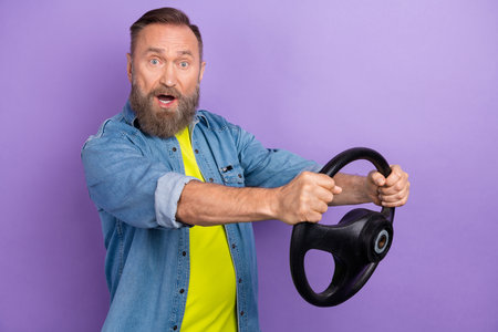 Profile photo of impressed aged man arms hold wheel open mouth isolated on violet color background