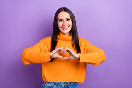 Photo of young positive adorable pretty woman smile wear orange turtleneck sweater show love symbol...