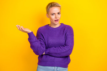 Portrait of upset unhappy confused dissatisfied woman with short hair violet sweater hold palm up...