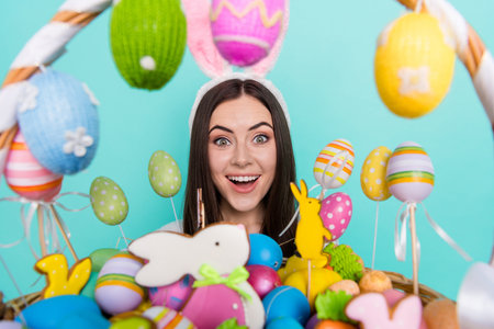 Photo of funky excited lady dressed striped pullover hare headband holding colorful easter eggs...