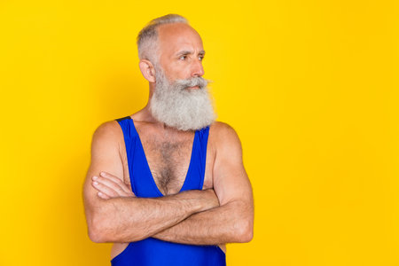 Photo of focused concentrated aged person folded hands look empty space isolated on yellow color backgroundの写真素材