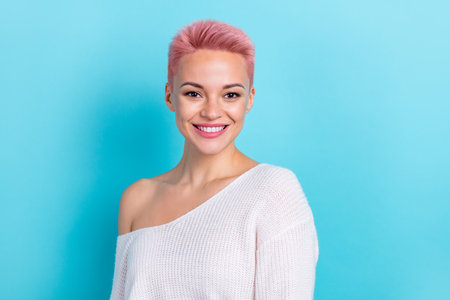 Photo of joyful cute nice lady wear white pullover stand near empty space banner blank empty space isolated on blue color backgroundの写真素材