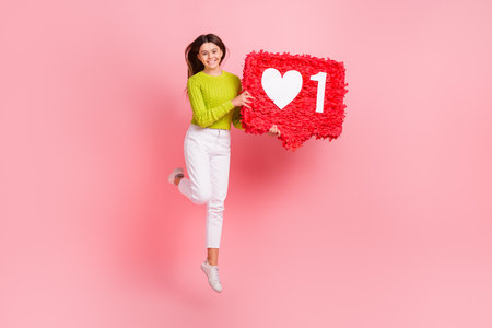 Full size photo of pretty young schoolgirl jumping high social media heart pinata wear trendy green...