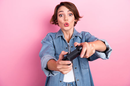 Photo of impressed funky lady dressed denim jacket playing video game isolated pink color background