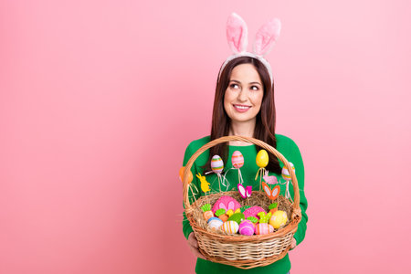 Photo of pretty cheerful person hands hold festive easter basket painted eggs cookies food look empty space isolated on pink color backgroundの写真素材