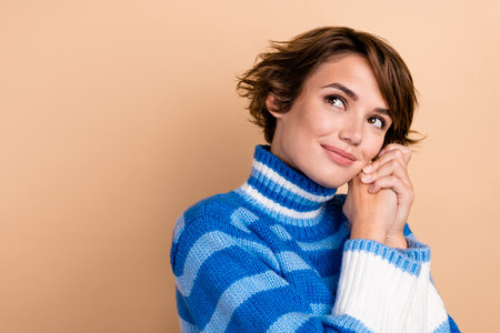 Photo portrait of dreamy lovely adorable girlish lady hands together cute dreaming look minded empty space promo isolated on beige color backgroundの写真素材