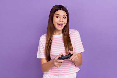 Photo of impressed funny girl dressed striped t-shirt enjoying game isolated purple color background