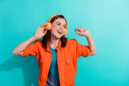 Photo of adorable lovely glad lady wear bright outfit good mood vibe chill look empty space isolated on cyan color backgroundの写真素材