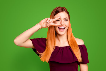 Closeup studio shooting photo portrait of chic attractive cute sweet lovely charming rejoicing delightful lady making v-sign near eyes laughing isolated bright backgroundの写真素材