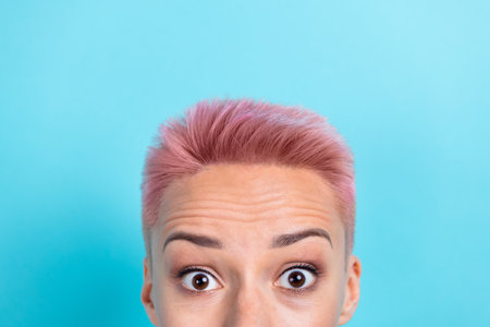 Cropped photo of young surprised funny girl shocked dyed pink hairstyle advertisement new shampoo lotion isolated on aquamarine color backgroundの写真素材