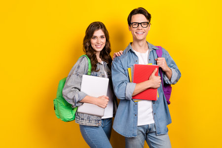 Photo of attractive funny best friends dressed denim starting college education isolated yellow...