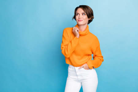 Photo portrait of lovely young lady touch collar model look empty space wear trendy orange garment isolated on blue color backgroundの写真素材