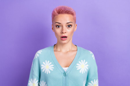 Photo of impressed astonished positive woman with short hairstyle dressed blue cardigan look at sale isolated on purple color backgroundの写真素材