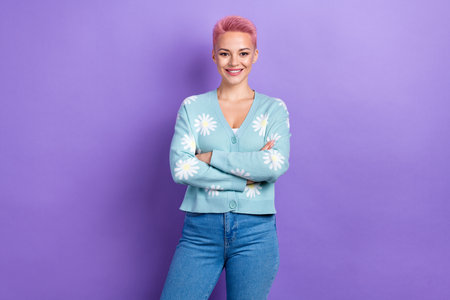 Photo of satisfied good mood cute woman with short hairstyle dressed blue cardigan hold arms crossed isolated on purple color backgroundの写真素材