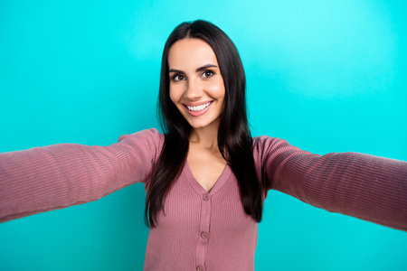 Photo of positive candid girl beaming smile make selfie record video isolated on teal color backgroundの写真素材