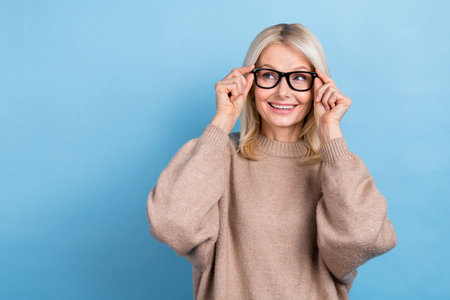 Photo of positive minded person hands touch glasses look empty space isolated on blue color backgroundの写真素材