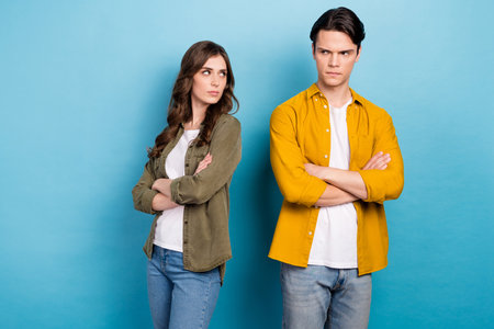 Photo of two best friends dissatisfied argue conflict problem relationship no support misunderstanding folded hands isolated on blue color backgroundの写真素材