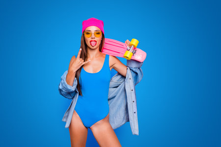 People person rest relax chill out concept. Photo shooting portrait of confident attractive stunning sticking out tongue lady holding board on shoulder isolated vivid backgroundの写真素材