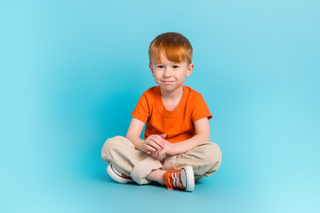 Portrait of positive cheerful boy wear orange stylish clothes relax rest good mood empty space isolated on cyan color backgroundの写真素材