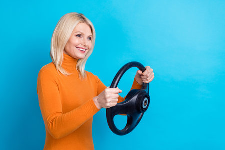 Photo of satisfied taxi driver woman hold her new  steering wheel copyspace road isolated on aquamarine color backgroundの写真素材