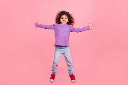 Full length photo of cute cheerful small kid wear violet sweater jumping high like star isolated pink color backgroundの写真素材