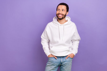 Portrait of cool positive minded person put hands pockets look empty space isolated on purple color backgroundの写真素材