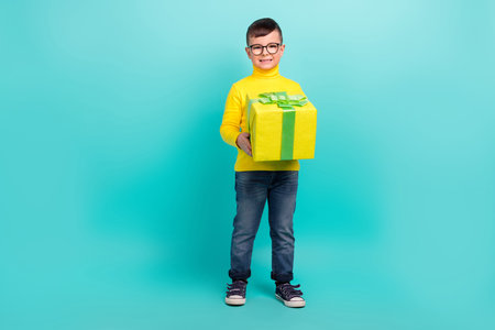 Full body photo of sweet son hold package prepare present for mother day isolated on cyan color backgroundの写真素材