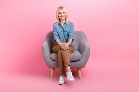 Photo of charming retired lady sit armchair look side dream psychology session wear casual outfit isolated pink color backgroundの写真素材