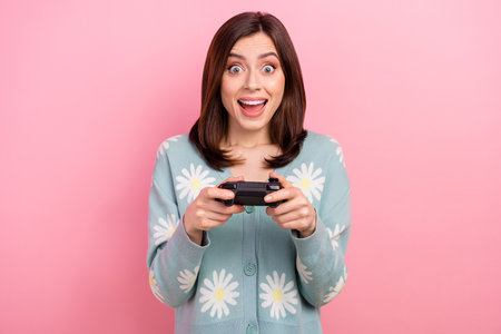 Closeup portrait of young funny surprised woman wear shirt play console  hold gamepad isolated on...