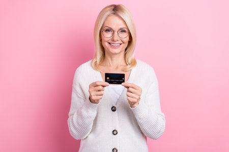 Photo of optimistic positive senior woman with bob hairdo dressed knit cardigan demonstrate credit...