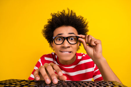 Photo of funky funny guy dressed red t-shirt hand eyewear typing modern gadget isolated yellow color backgroundの写真素材