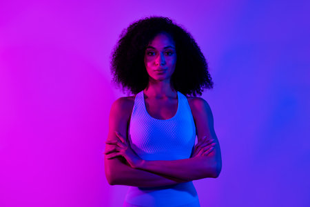 Photo of serious focused fitness instructor girl crossed arms posing isolated on neon ultraviolet color backgroundの写真素材