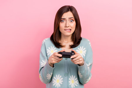 Photo of excited nervous lady wear turquoise clothes biting lip losing game isolated pink color...