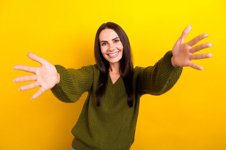 Photo of satisfied glad person beaming smile raise opened arms welcome you isolated on yellow color backgroundの写真素材