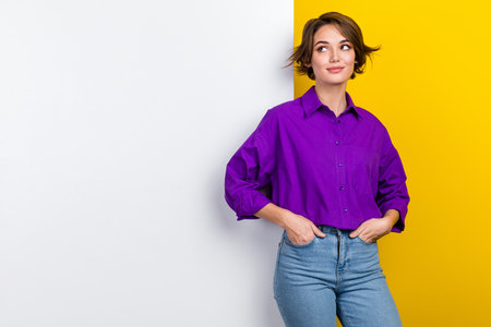 Photo portrait of pretty young girl look interested white poster wear trendy violet smart casual outfit isolated on yellow color backgroundの写真素材