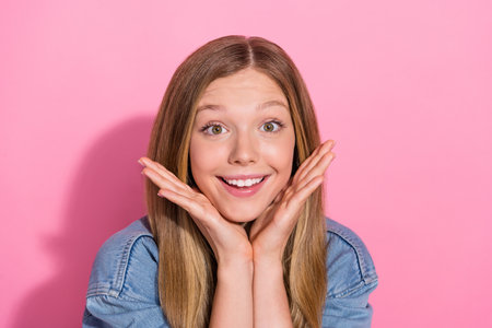 Photo portrait of lovely young teenager lady hands frame face smile charming wear trendy jeans garment isolated on pink color backgroundの写真素材