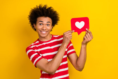 Portrait of cheerful nice person toothy smile hands hold paper like notification card isolated on yellow color backgroundの写真素材
