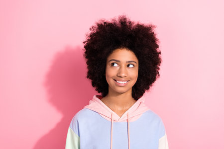 Photo of cheerful minded lovely girl beaming smile look interested empty space ad isolated on pink color backgroundの写真素材